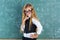 Nerd pupil blond girl in green board schoolgirl