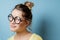 Nerd young woman on a blue background. Studio shot