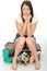 Nervous Anxious Attractive Young Woman Sitting on an Overflowing Suitcase