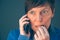 Nervous businesswoman bites fingernails during telephone convers