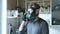 Nervous man in gas mask speaks smartphone at kitchen at home. virus protection