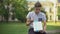 Nervous teenager sitting on bench holding gift box and waiting for girlfriend