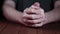 Nervous woman squeezes her hands on the table. Close-up of hands