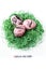 Nest of green grass with three pink marbled easter eggs and letters saying Happy Easter in German on white background.