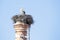 Nest with a stork on top of a factory chimney.
