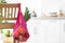 Net bag with vegetables hanging on wooden chair in kitchen