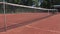 A net on the tennis court in the summer