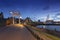 Netherlands - Hindeloopen - a magical evening view of a stone path that leads over a drawbridge to the harbor, where boats are