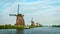Netherlands landscape with tourist boat and windmills at famous tourist site Kinderdijk in Holland
