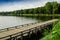 Netherlands, Zeeland region. August 2019. The beautiful pond of a campsite: the wooden pier goes into the water, in the background