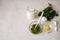 Nettle dioecious, milk, egg yolk and ready-made mask in a cup with a spatula close-up on a pastel pink marble background.