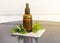 Nettles essential oil or infusion in brown medical pipette bottle with decorative nettle branches wooden board background.