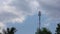 Network communication tower mast cloudscape and treetops