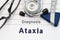 Neurological diagnosis of Ataxia. Neurological hammer, stethoscope and doctor`s glasses lie on doctor workplace on sheet of notebo