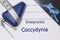 Neurological diagnosis of Coccydynia. Neurologist directory, where is printed diagnosis Coccydynia, lies on workplace with MRI ima