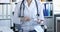 Neuropathologist doctor in white coat holds hammer at workplace