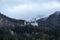 Neuschwanstein castle in a autumn winter forest with fog and clouds