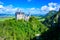 Neuschwanstein Castle in beautiful mountain scenery of Alps- in the background you can see the Lake Forggensee - near Fuessen,