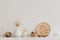 Neutral vases on a white shelf against rough stucco of a gray wall. Home decor