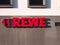 Neuwied, Germany - November 12, 2020: red REWE Label with triangles as directional signs outside on a wall
