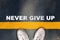 Never give up written on yellow line on asphalt road