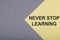 NEVER STOP LEARNING text on gray-yellow background