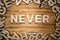 NEVER word made with block letters lying on wooden board