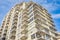 New apartment building on a sunny day with a blue sky. Facade of a modern multistoried new stylish living block of flats