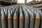 New artillery shells stored in warehouse of weapons factory, metal munition in military storage close-up. Concept of war,