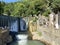 New Athos, Abkhazia, August, 09. 2019. People walking near artificial waterfall on the river Psyrtskha in the summer, the city of