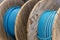 New blue power cable is wound on wooden coil. Background.