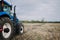 New blue tractor Holland in motion at demonstration field site at agro exhibition AgroExpo. Tractor working on the farm, modern