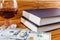 New books, dollars and a glass of red wine on a wooden background