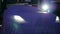 New cars with burning headlights under blue tissue indoors close-up in lighting of floodlight