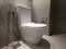 New ceramic toilet bowl, faucet and paper holder. Toilet bowl in modern bathroom interior with grey walls and grey floor