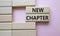 New Chapter symbol. Concept word New Chapter on wooden blocks. Beautiful pink background. Business and New Chapter concept. Copy