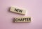 New Chapter symbol. Concept word New Chapter on wooden blocks. Beautiful pink background. Business and New Chapter concept. Copy