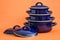 New And Clean Covered Dark Blue Saucepans on Orange Background