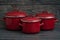 New And Clean Covered Red Saucepans on Blue Wooden Background