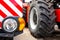 new clean right headlight with reflector on the bumper of the combine against the background of the wheel of another agricultural