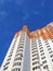 New colorful orange building, blue sky, clouds