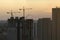 New construction site of developing residense in american urban area at sunset. Industrial tower lifting cranes in Miami