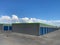 new construction storage rental building business stalls shed garage doors blue gray paved driveway industrial building