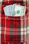 New dollar notes in checkered shirt pocket
