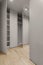 New empty modern closet wardrobe shelves by grey finish material and opened doors.