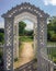 New England white wooden arbor garden gates and sunlit path