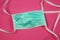New fashion accessory concept: Closeup of isolated green personal surgical protection face mask on pink background
