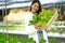 New generation, young Asian businesswoman holding wooden box with vegetable organic salad from hydroponics while working inside