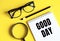 New GOOD DAY text  written on a notebook with glasses, magnifying glass and pencil