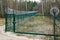 A new green metal mesh fence with coiled barbed wire and gate around the restricted area